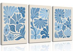 three canvases with blue flowers on them, one in white and the other in light blue