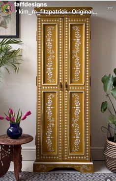 an ornate armoire is painted in gold and white with flowers on the bottom shelf