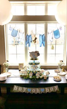 a baby shower table with blue and white decorations