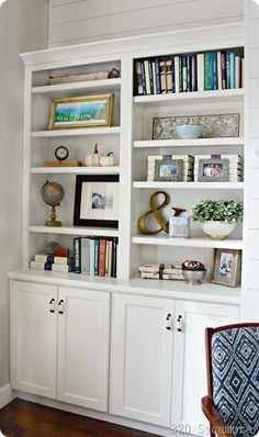 a white bookcase with books and pictures on it