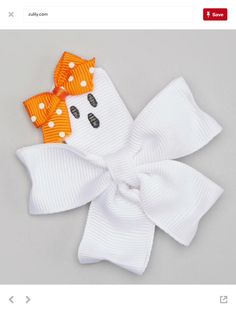 a white bow with orange polka dots and a ghost face on the front is shown