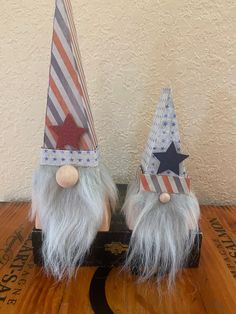 two gnomes wearing patriotic hats on top of a wooden table