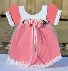 a pink and white dress sitting on top of a table