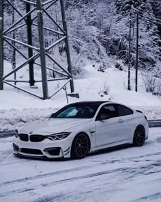 a white car driving down a snow covered road