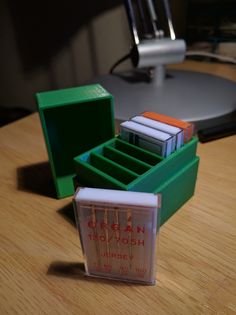 three small plastic boxes sitting on top of a wooden table