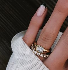 a woman's hand with two rings on it and a ring in the middle