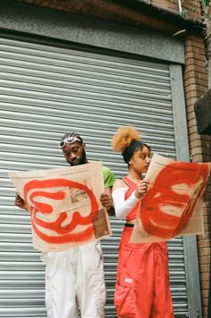 two people standing on the street holding up signs that read 50 and there is no image