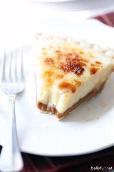 a slice of cheese pizza on a white plate with a fork and knife next to it