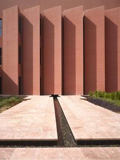 the building is pink and has water running from it's sides in front of it