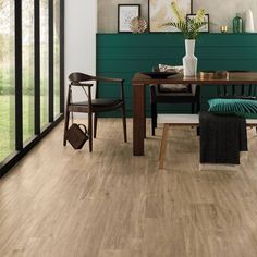 a dining room with wood flooring and green walls