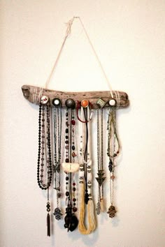 a wooden jewelry organizer hanging on a wall