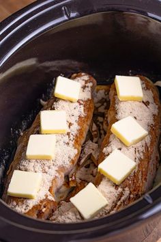 two pieces of bread with butter on top in a slow cooker