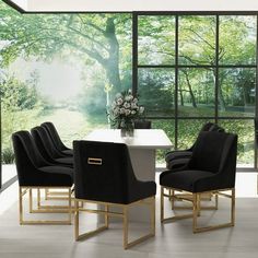 a dining room with black chairs and a white table in front of large glass windows