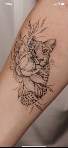 a woman's arm with a leopard and flowers tattoo on it