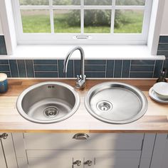 two stainless steel kitchen sinks under a window