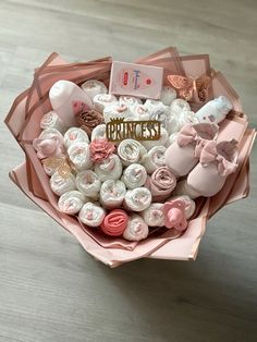 a pink bouquet with baby items in it