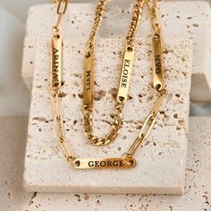 Our Engraved Name Necklace lets you wear your loved ones close. Choose one or more name bars, each engraved on both sides. Pick your chain style: curb or paperclip, available in 14", 16", or 18" lengths, plus a 2" extender. Made from stainless steel with 18k gold PVD plating or a silver finish, this necklace is waterproof and tarnish-free/ Material: Stainless Steel  Finish: Silver and 18k Gold PVD Plated Chain Type: Dainty Paperclip & 3mm Curb Chain Length: 14", 16" and 18" + 2" extender Number Gold Name Plate, Family Necklace, Jewelry Card, Bar Bracelets, Name Bracelet, Curb Chain, Papua New Guinea, Bar Necklace, Pitcairn Islands