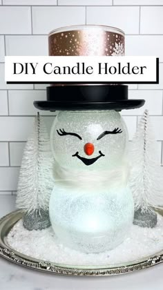 a glass snowman with a top hat on it's head and the words diy candle holder above it