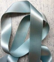 a light blue satin ribbon is laying on the floor