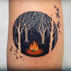 a man's leg with a forest scene and fire in the woods on it