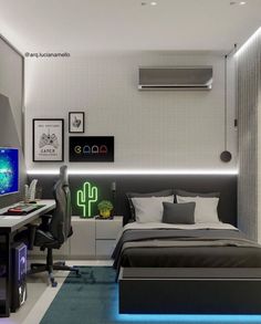 a bed room with a neatly made bed next to a computer desk and monitor on top of it