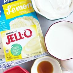 ingredients to make lemon jello on a table with plates and bowls, including milk