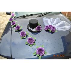 purple flowers on the hood of a car with a top hat and white tissue paper