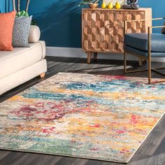 a living room area with blue walls and colorful rugs on the hardwood flooring