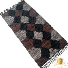 a brown and black checkered rug with fringes on the bottom, in front of a white background