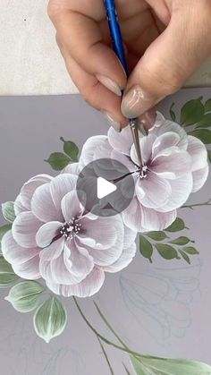 someone is drawing flowers on a piece of paper