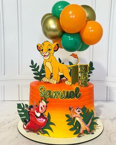 a lion themed birthday cake with balloons on the top and an i - is for samuel sign