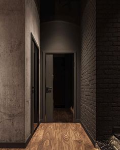 an empty hallway with black walls and wooden floors