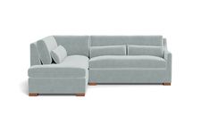 a gray couch with pillows on it and a footstool in front of it