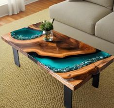 a coffee table made out of wood and turquoise glass in the middle of a living room