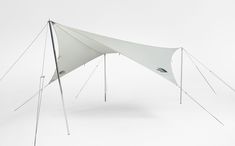 an upside down white tent sitting on top of a white floor next to a wall