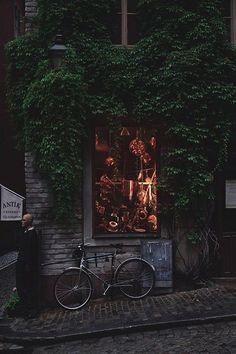 a bike parked next to a building covered in ivy