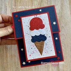 a hand holding up a card with an ice cream cone on it and stars in the background