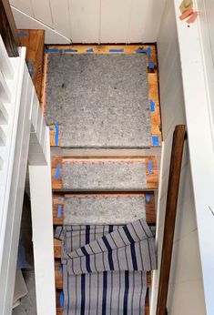 the stairs are being built into the wall in this small room with carpeted flooring