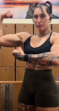 a woman with tattoos on her arm posing for the camera