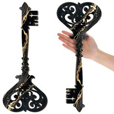 a hand holding an ornate black and gold key with intricate carvings on it's sides