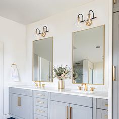 a bathroom with two sinks and mirrors in it