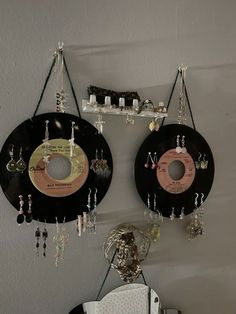 there are two records hanging on the wall next to each other with earring hooks