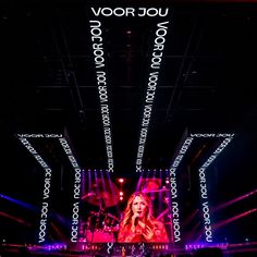 a woman standing on top of a stage in front of purple and red lights with the words voor jojo written all over her