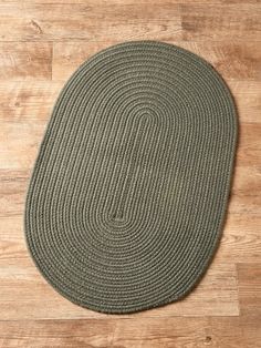 an oval rug on a wooden floor with a wood flooring board in the background