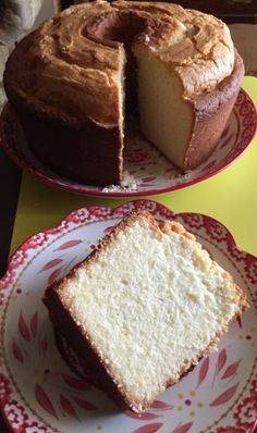 two plates with cakes on them sitting on a table next to each other and one has a slice missing