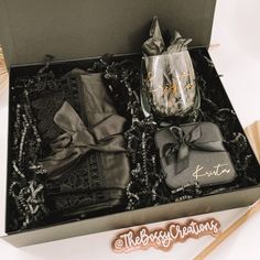 an open gift box containing two glasses and some napkins