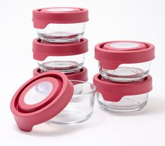 four glass containers with lids are stacked on top of each other