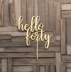 a cake topper that says hello forty on the side of a wooden wall with wood planks