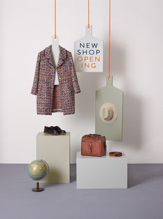 an assortment of clothing and accessories displayed on pedestals in front of a white wall