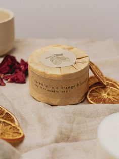 an orange slice next to a cup and some dried orange slices on a table cloth